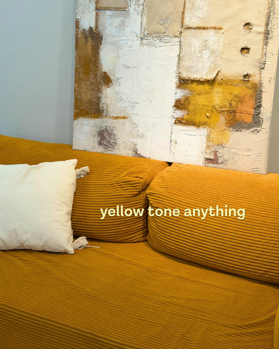 Slide captioned 'yellow tone anything', showing a mustard corduroy sofa with a cream cushion and a textured abstract painting (slide 2 of 4)